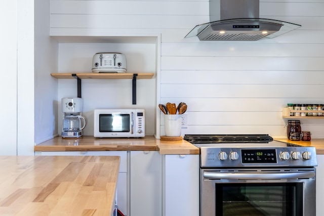 kitchen with electric range, wood walls, wooden counters, and island range hood