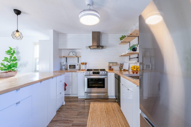 kitchen featuring ventilation hood, stainless steel appliances, dark wood-type flooring, white cabinets, and hanging light fixtures