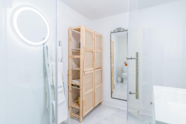 bathroom with vanity, toilet, and a shower with door