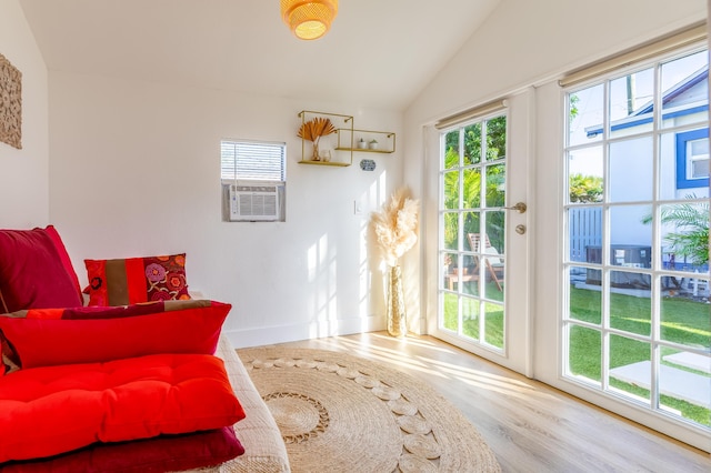 sitting room featuring hardwood / wood-style flooring, cooling unit, and lofted ceiling