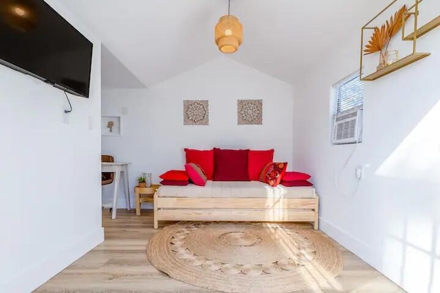 bedroom with wood-type flooring and vaulted ceiling