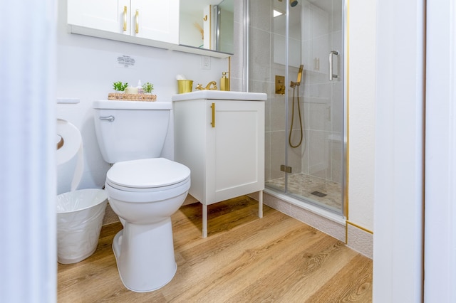 bathroom with vanity, hardwood / wood-style flooring, toilet, and an enclosed shower