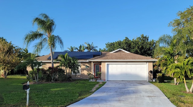 single story home with solar panels, a garage, and a front lawn