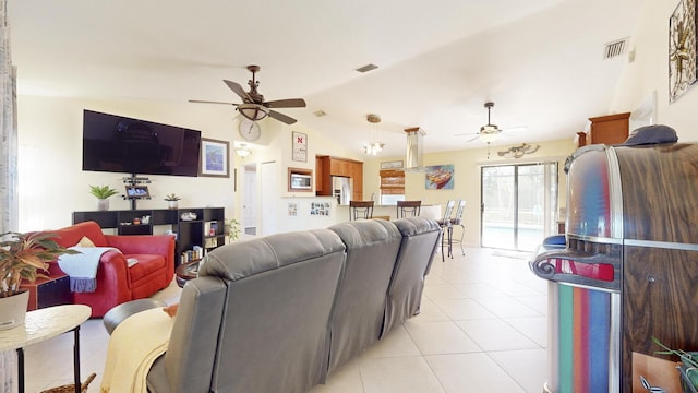 living room with ceiling fan, light tile patterned flooring, and vaulted ceiling