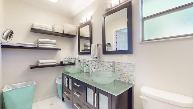 bathroom featuring vanity, toilet, and backsplash