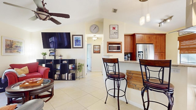 kitchen featuring ceiling fan, hanging light fixtures, lofted ceiling, and appliances with stainless steel finishes