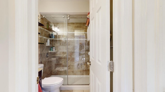 bathroom with an enclosed shower, tile patterned flooring, and toilet