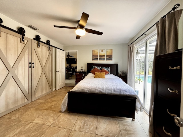 bedroom featuring access to outside, a barn door, and ceiling fan