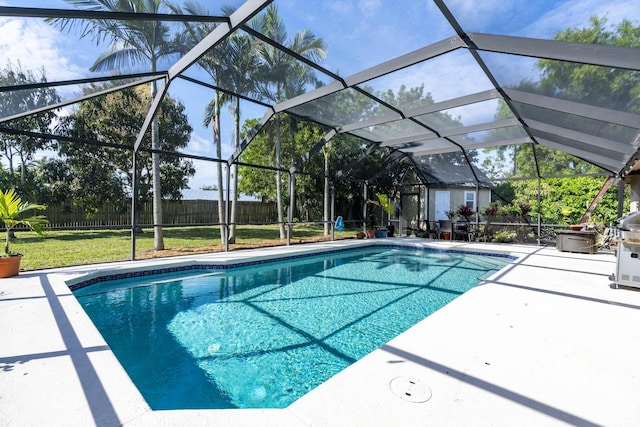 view of pool with a lanai, a patio area, and a yard