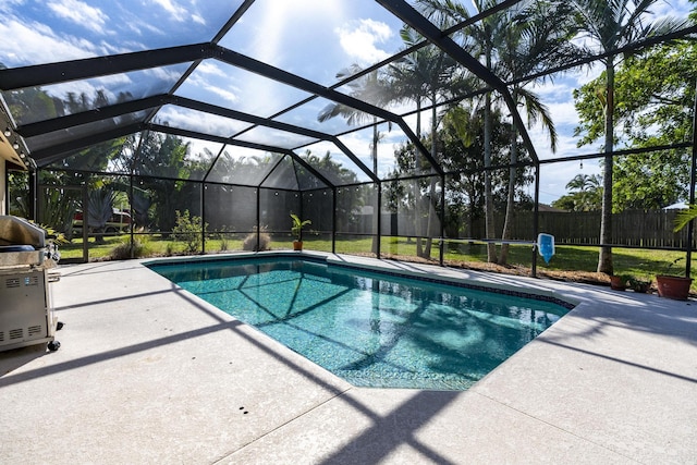 view of pool with glass enclosure and a patio area