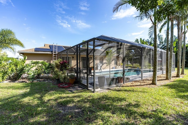 view of pool with glass enclosure and a yard