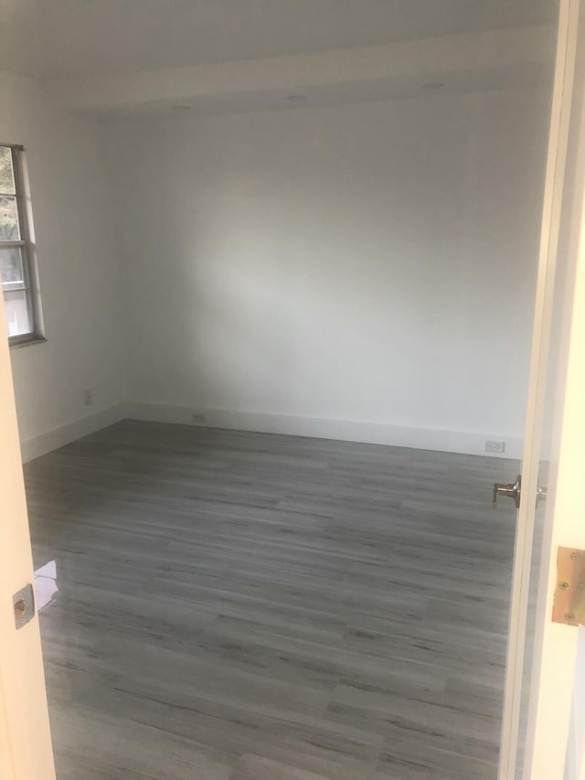 unfurnished room with dark wood-type flooring