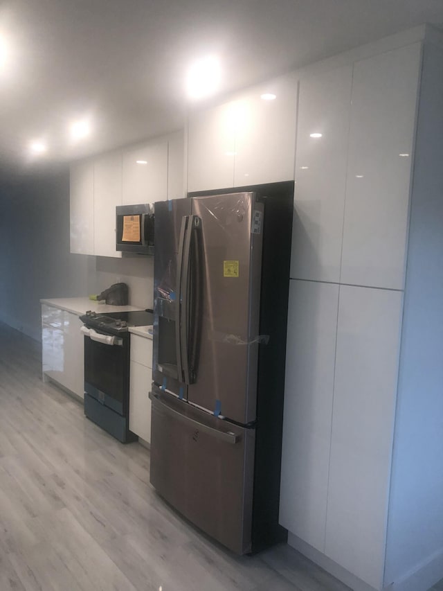 kitchen featuring white cabinetry, electric range, light hardwood / wood-style floors, and stainless steel refrigerator with ice dispenser