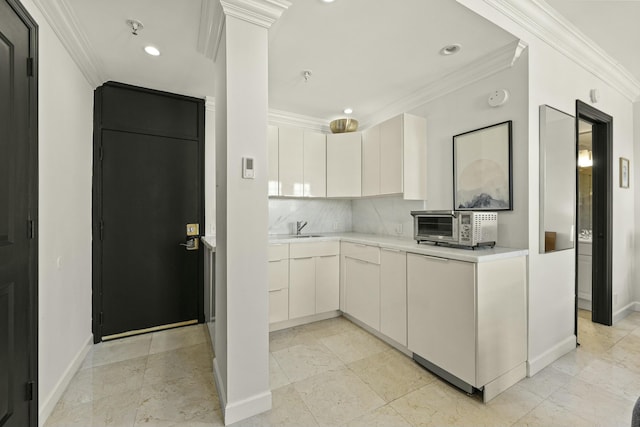 kitchen with tasteful backsplash, white cabinetry, and ornamental molding