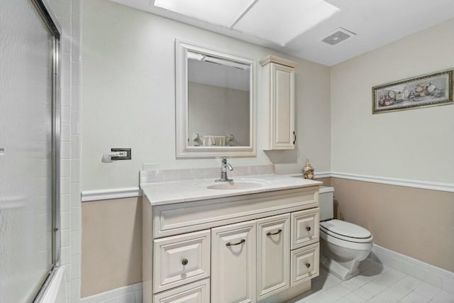 full bathroom featuring combined bath / shower with glass door, vanity, toilet, and tile patterned floors