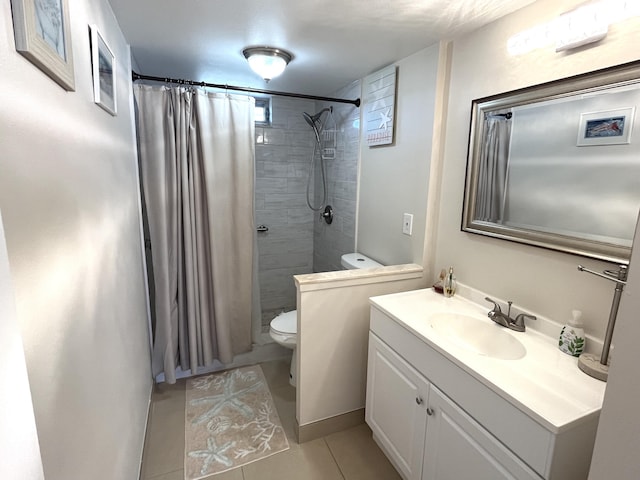 bathroom featuring toilet, tile patterned flooring, vanity, and walk in shower