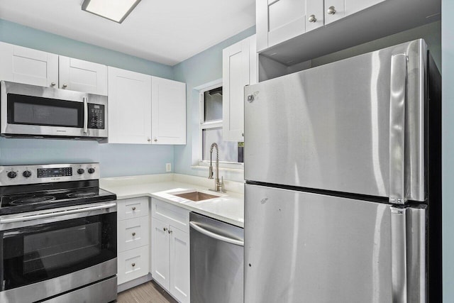 kitchen featuring white cabinets, appliances with stainless steel finishes, and sink