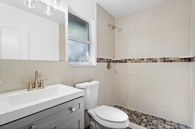 bathroom with vanity, toilet, and a tile shower