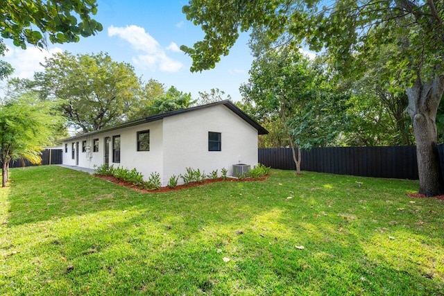 view of side of home featuring a yard and central AC