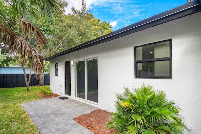 back of property with a lawn and a patio