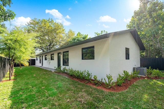 view of front of property featuring central air condition unit and a front lawn