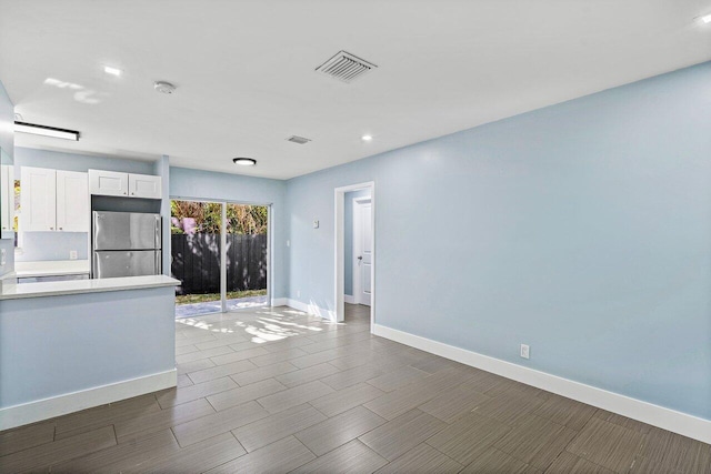 kitchen with white cabinetry and stainless steel refrigerator