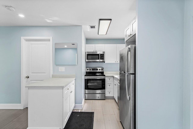 kitchen with white cabinets and appliances with stainless steel finishes