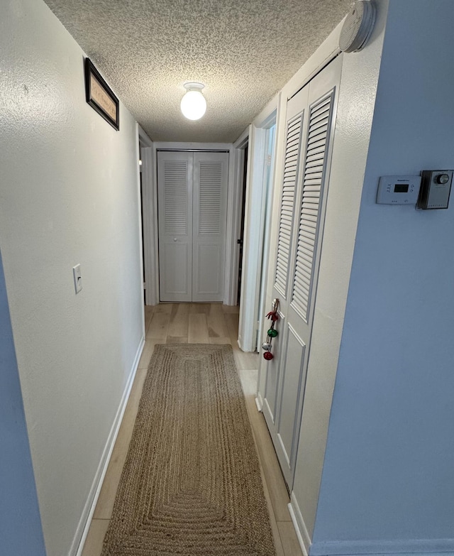 hall featuring a textured ceiling