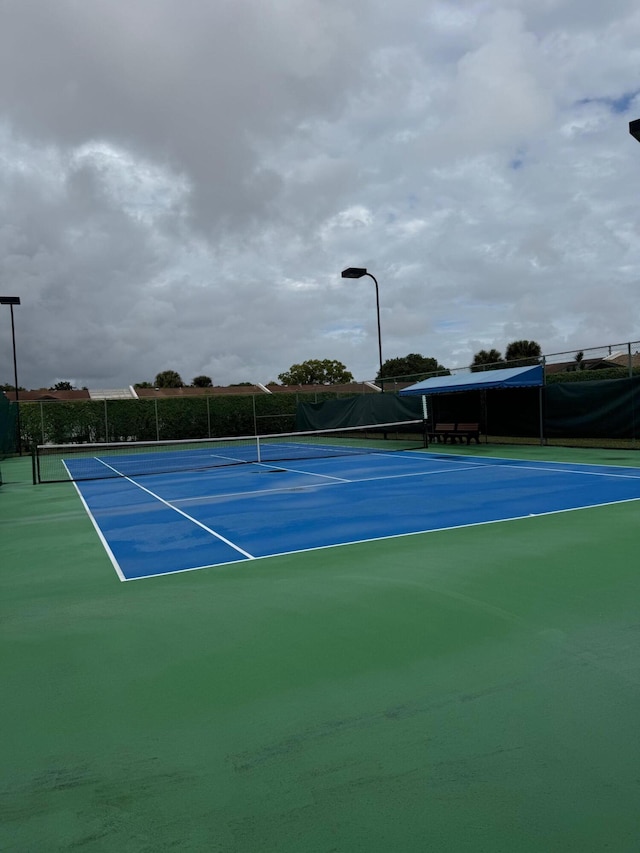 view of tennis court featuring basketball hoop