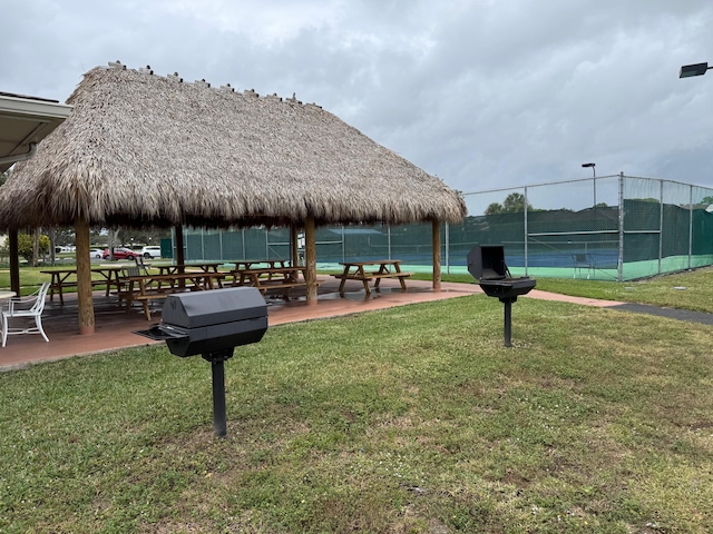 view of home's community with a gazebo, a lawn, and tennis court