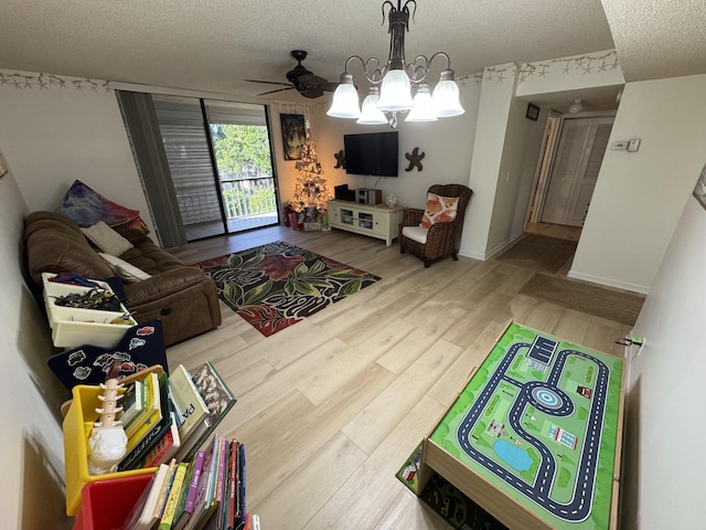 game room featuring ceiling fan with notable chandelier, a textured ceiling, and hardwood / wood-style flooring