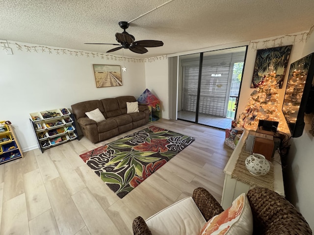 living room with hardwood / wood-style floors, a textured ceiling, and ceiling fan