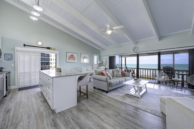 kitchen featuring ceiling fan, high vaulted ceiling, light hardwood / wood-style floors, a water view, and white cabinets