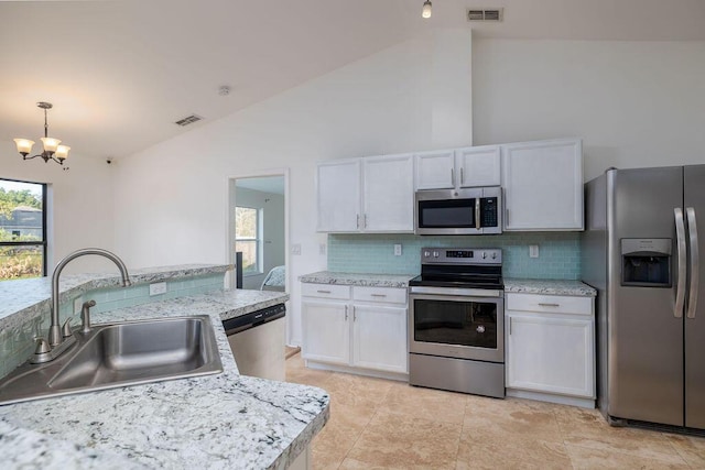 kitchen with white cabinets, appliances with stainless steel finishes, lofted ceiling, and sink