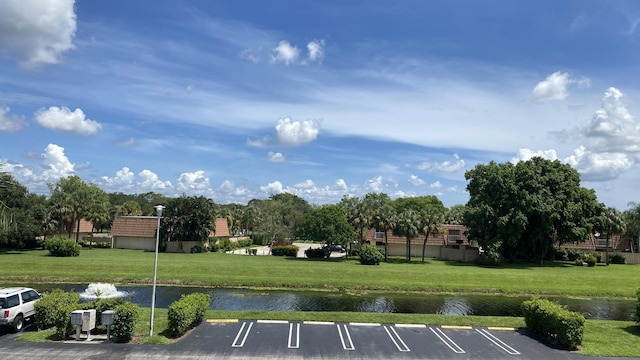 surrounding community featuring a water view and a lawn