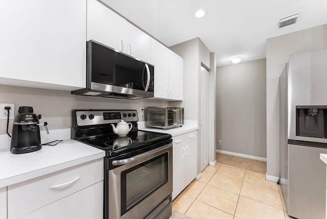 kitchen featuring white cabinets, light tile patterned floors, and appliances with stainless steel finishes