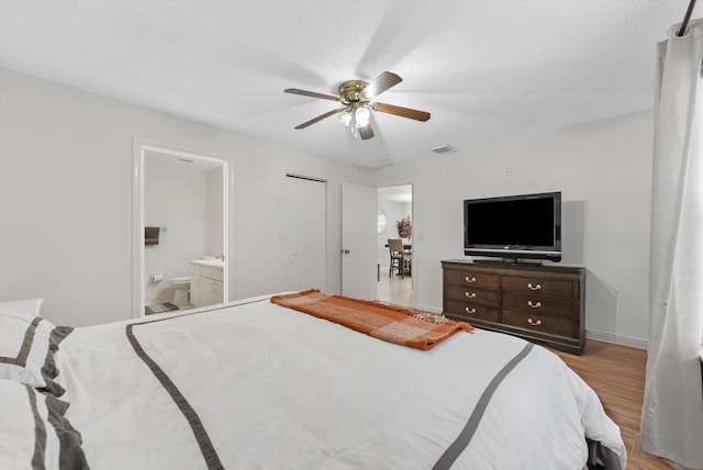 bedroom with connected bathroom, ceiling fan, a textured ceiling, and light wood-type flooring