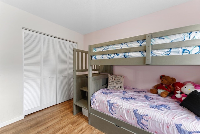 bedroom with light hardwood / wood-style flooring and a closet