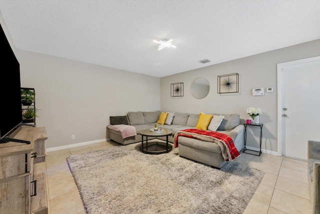 living room with light tile patterned flooring and a textured ceiling