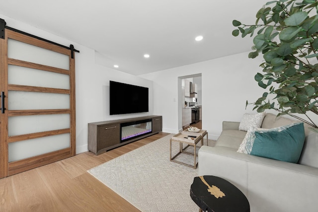 living room featuring a barn door and light wood-type flooring