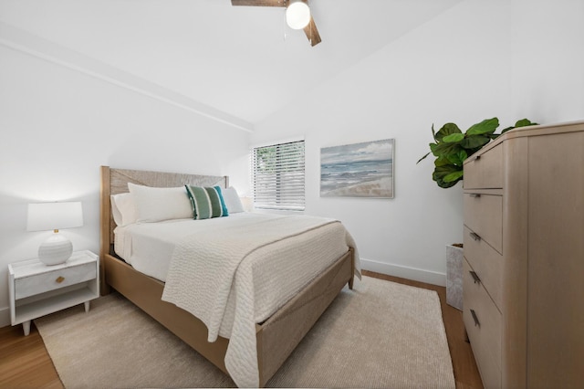 bedroom with light wood-type flooring, vaulted ceiling, and ceiling fan