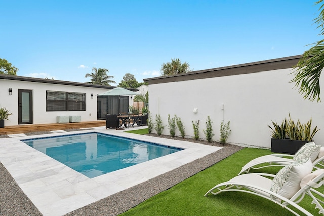 view of swimming pool featuring a patio and a wooden deck