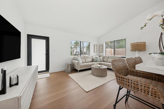 living room with light wood-type flooring and lofted ceiling