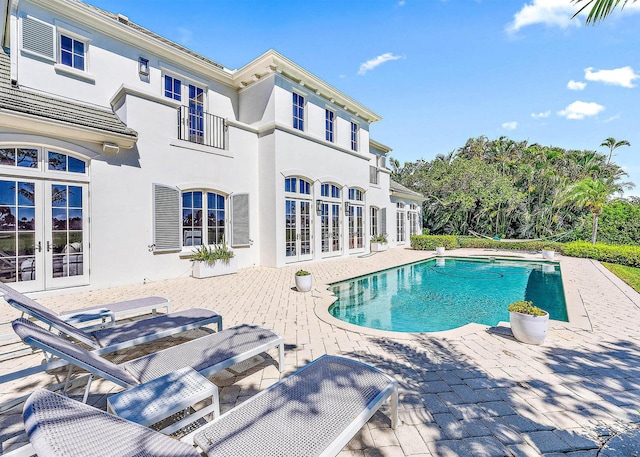 view of swimming pool with french doors and a patio