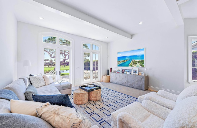 living room featuring beamed ceiling and french doors