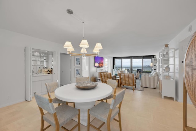 dining space featuring a wall of windows and a chandelier