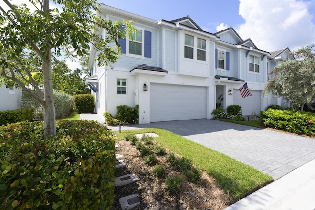 view of front of home featuring board and batten siding, decorative driveway, and a garage