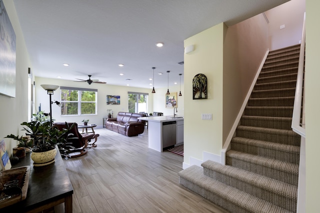 living area featuring baseboards, stairway, recessed lighting, light wood-style floors, and a ceiling fan