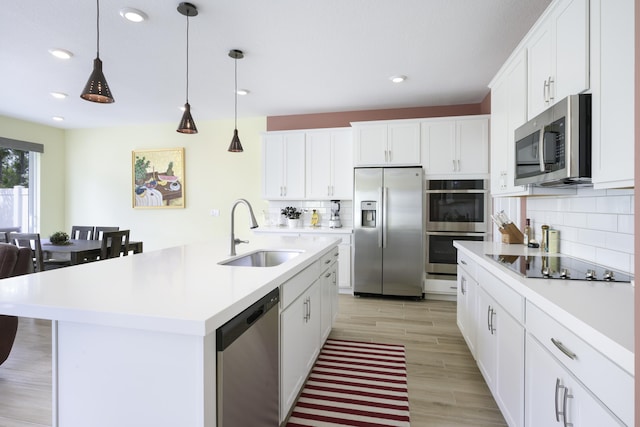 kitchen with white cabinets, sink, an island with sink, and stainless steel appliances