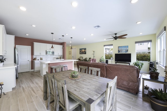 dining space featuring ceiling fan and light wood-type flooring